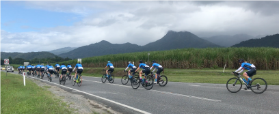 A large group of cyclists with mountains in the background