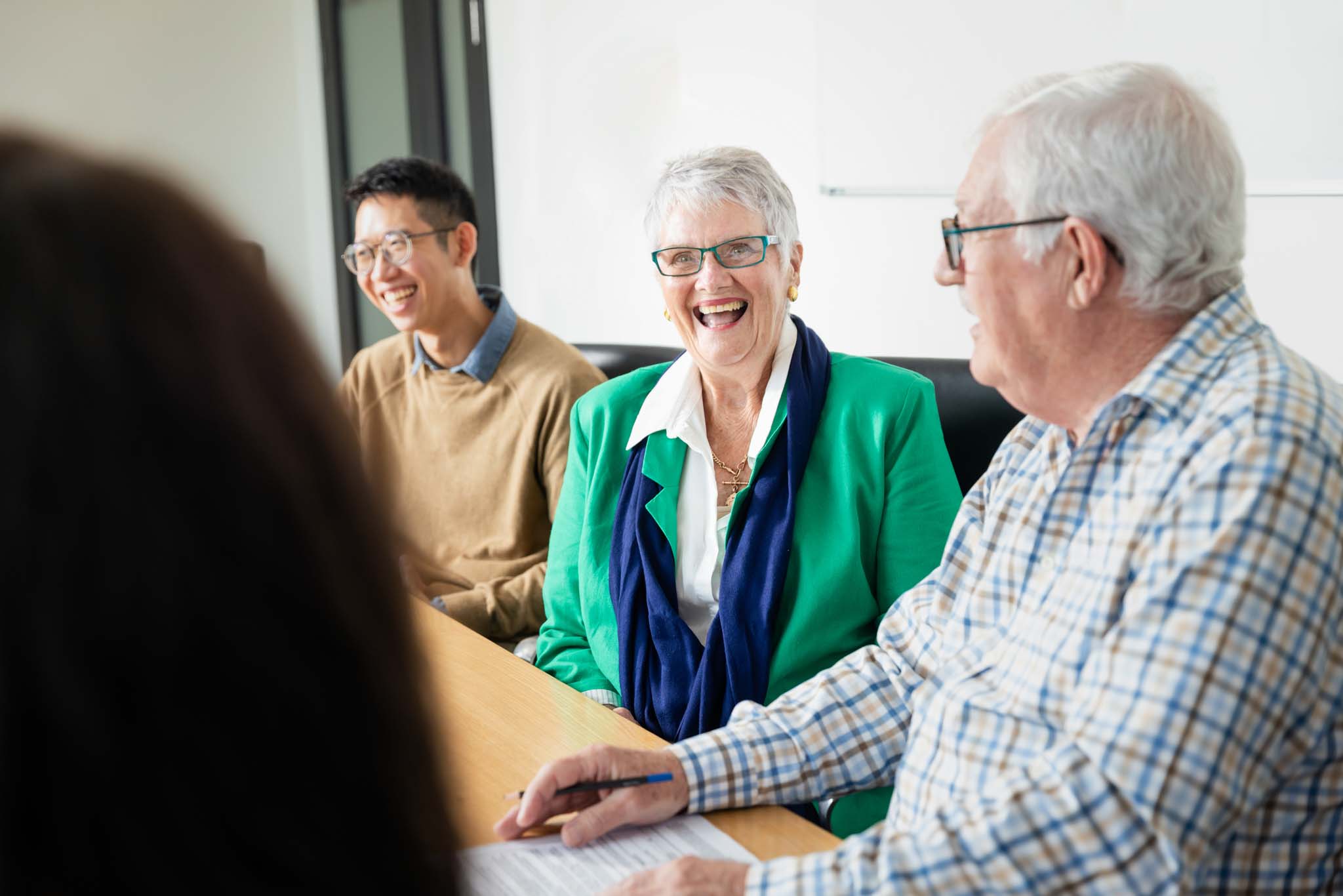 Picture of elderly people in a meeting room smiling