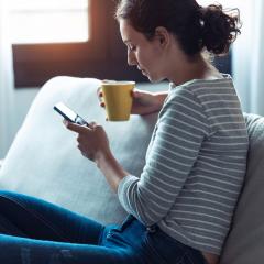 woman on cough looking at phone