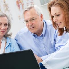 doctor and patients looking at laptop